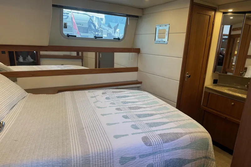 Lost Together Yacht Photos Pics 1996 Bayliner 4087 Aft Cabin Motoryacht bedroom with bed, window, and wooden cabinetry.