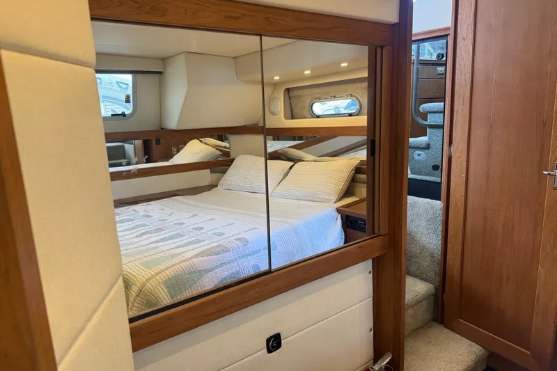 Lost Together Yacht Photos Pics Cozy bedroom in 1996 Bayliner 4087 Aft Cabin Motoryacht with mirrored closet and wooden accents.