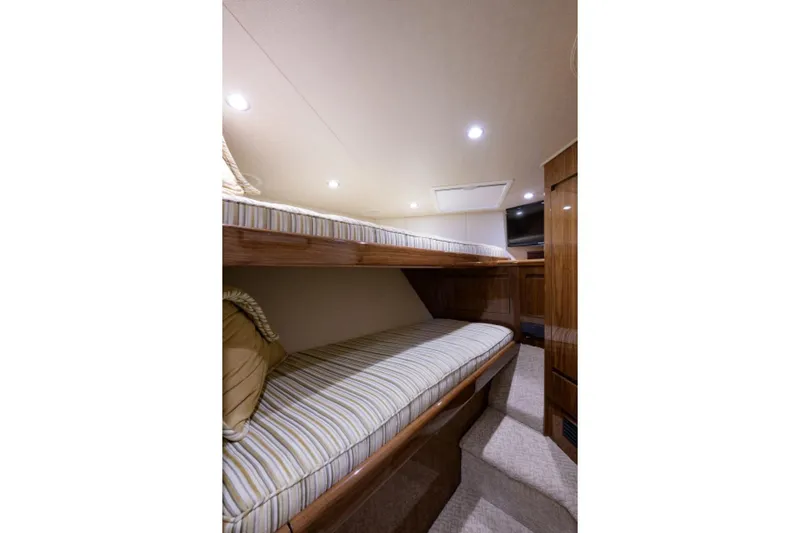 Andiamo Yacht Photos Pics Interior of 2017 Viking 48 Convertible yacht with cozy bunk beds and wooden finish.