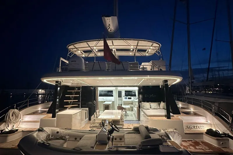 Dolphin Yacht Photos Pics Luxurious 2019 Sunreef 50 yacht illuminated at night, showcasing elegant design and spacious deck.