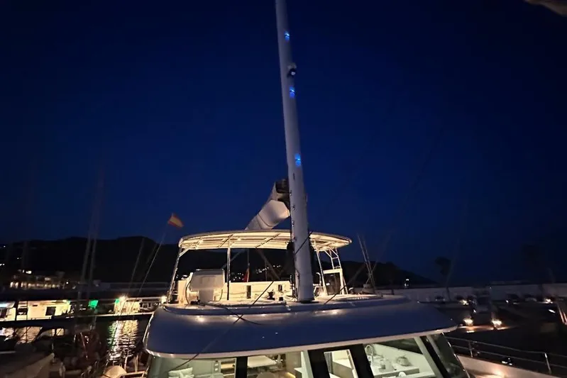 Dolphin Yacht Photos Pics 2019 Sunreef 50 yacht docked at night, illuminated with blue lights.
