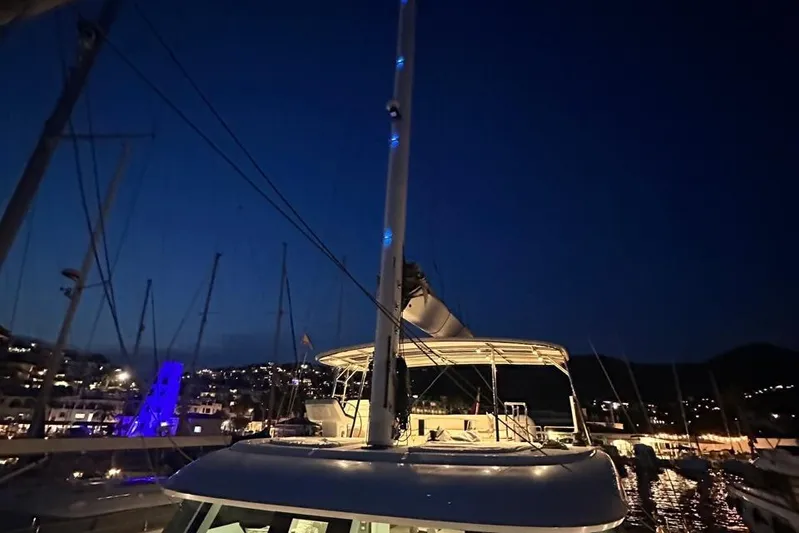 Dolphin Yacht Photos Pics 2019 Sunreef 50 yacht docked at night with illuminated mast and marina view.