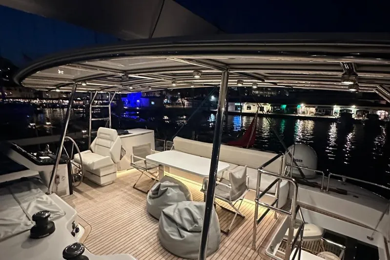 Dolphin Yacht Photos Pics Luxurious 2019 Sunreef 50 yacht deck at night, featuring seating and waterfront view.
