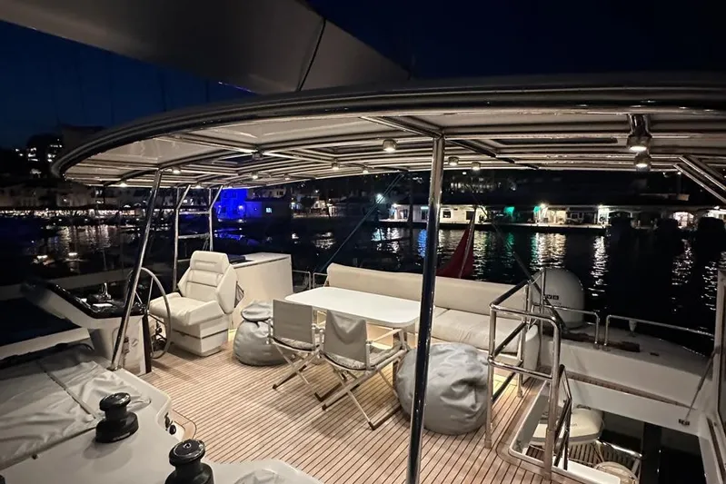 Dolphin Yacht Photos Pics Luxurious 2019 Sunreef 50 yacht deck at night, featuring elegant seating and waterfront view.