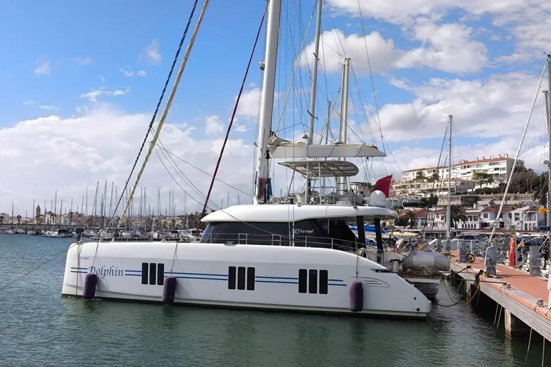 Dolphin Yacht Photos Pics 2019 Sunreef 50 catamaran docked in a marina under a partly cloudy sky.