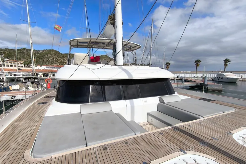 Dolphin Yacht Photos Pics 2019 Sunreef 50 catamaran docked at marina, featuring spacious deck and modern design.