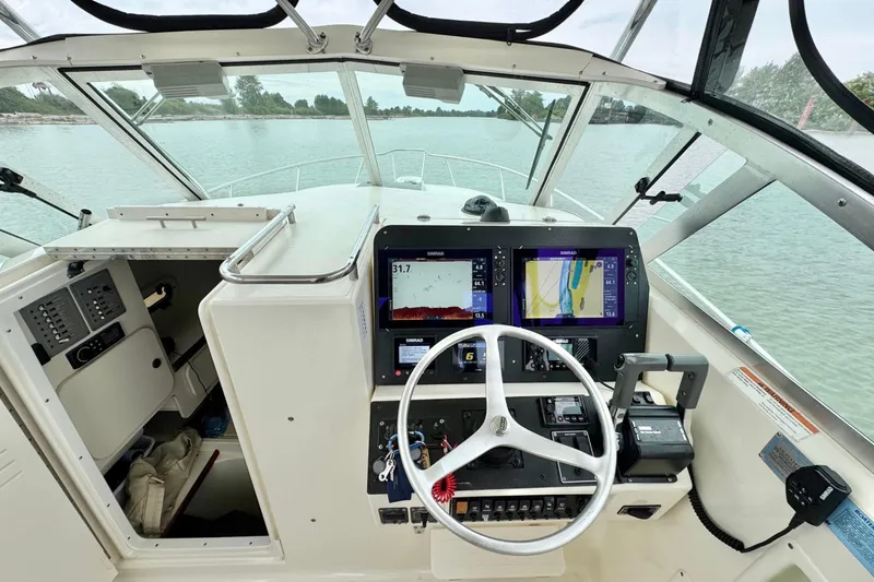  Yacht Photos Pics 2004 Pursuit 2870 Walkaround boat cockpit with navigation screens and steering wheel.