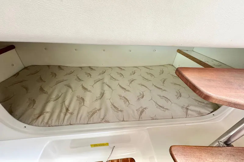  Yacht Photos Pics 2004 Pursuit 2870 Walkaround cabin with patterned mattress and wooden steps.