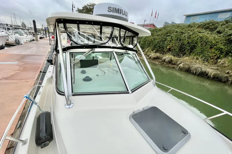  Yacht Photos Pics 2004 Pursuit 2870 Walkaround boat docked, featuring a Simrad radar and sleek design.