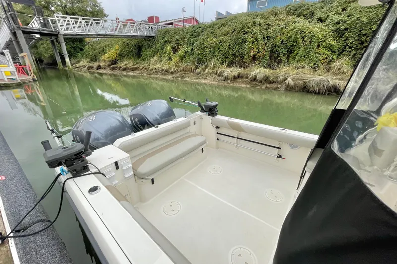  Yacht Photos Pics 2004 Pursuit 2870 Walkaround boat docked by a lush, green canal.