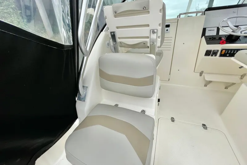  Yacht Photos Pics 2004 Pursuit 2870 Walkaround boat interior with cushioned seating and steering console.