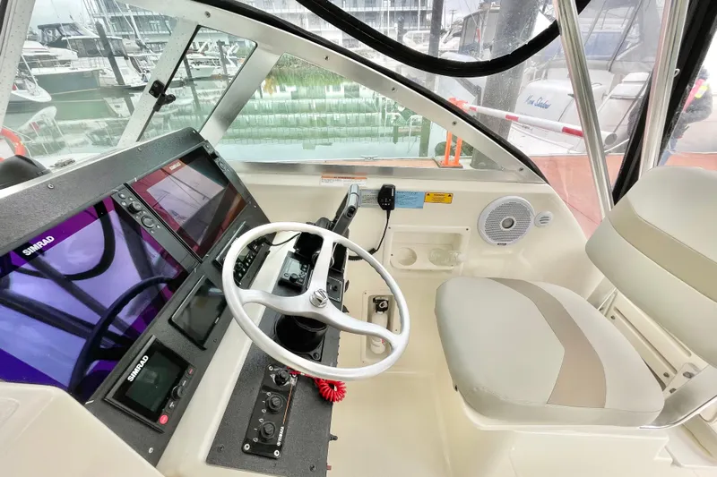  Yacht Photos Pics 2004 Pursuit 2870 Walkaround helm with Simrad displays and steering wheel.