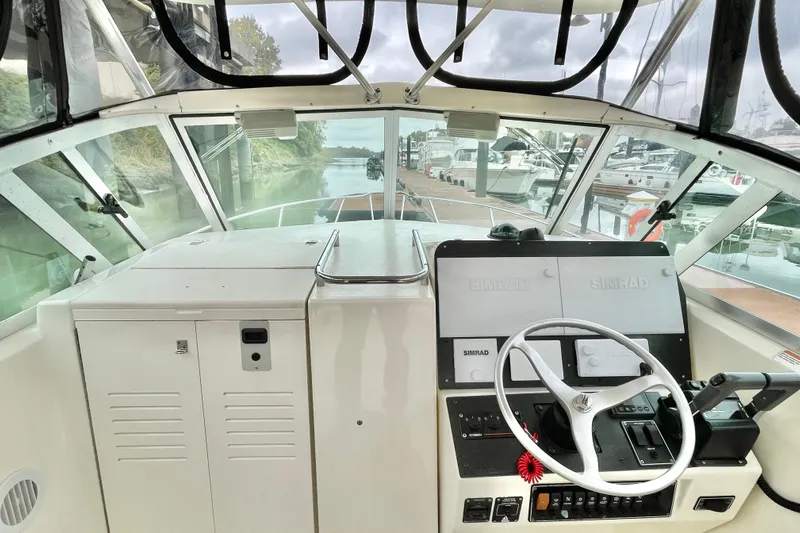  Yacht Photos Pics 2004 Pursuit 2870 Walkaround boat cockpit with steering wheel and navigation equipment.