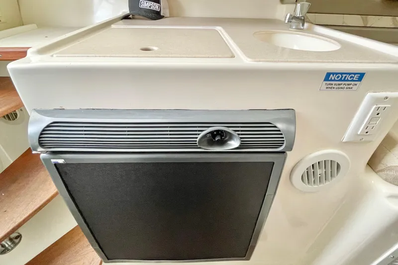  Yacht Photos Pics 2004 Pursuit 2870 Walkaround boat interior with sink, countertop, and mini fridge.