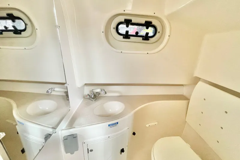  Yacht Photos Pics 2004 Pursuit 2870 Walkaround boat interior with sink and porthole window.