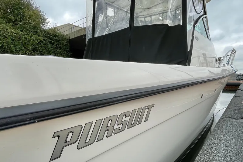  Yacht Photos Pics 2004 Pursuit 2870 Walkaround boat docked, showcasing sleek design and branding.