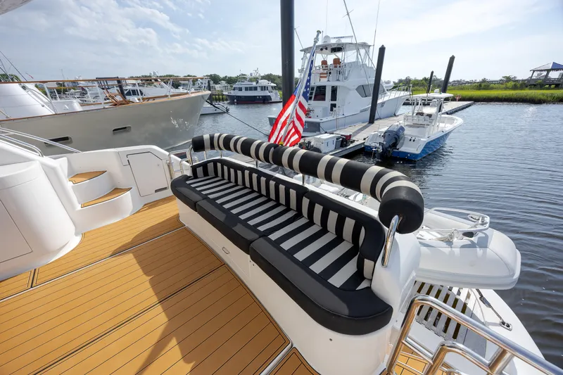  Yacht Photos Pics Luxurious 2004 Neptunus 56 Flybridge yacht with striped seating, docked at marina.