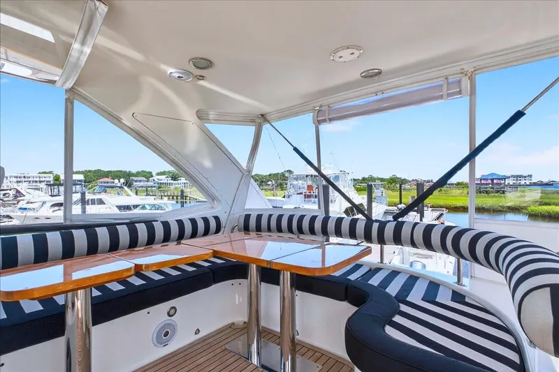  Yacht Photos Pics Luxurious 2004 Neptunus 56 Flybridge yacht interior with striped seating and scenic marina view.