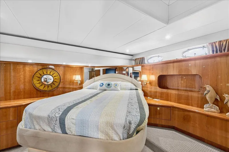  Yacht Photos Pics Luxurious bedroom interior of 2004 Neptunus 56 Flybridge yacht with elegant wood paneling.