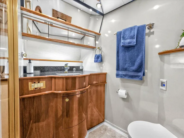  Yacht Photos Pics Luxurious bathroom in 2004 Neptunus 56 Flybridge yacht with wooden cabinetry and blue towels.