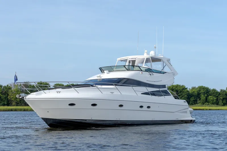  Yacht Photos Pics 2004 Neptunus 56 Flybridge yacht cruising on a calm river.