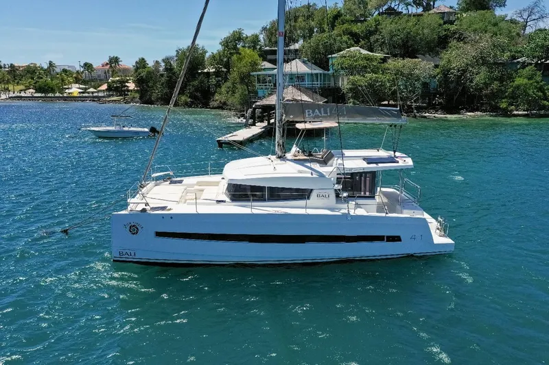 Viewfinder Yacht Photos Pics 2020 Bali 4.1 catamaran sailing in clear blue waters near lush coastline.