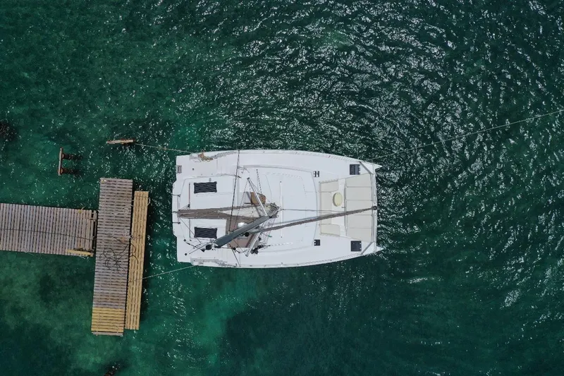 Viewfinder Yacht Photos Pics Aerial view of a 2020 Bali 4.1 catamaran docked on clear turquoise water.