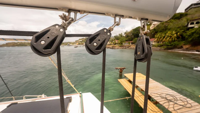 Viewfinder Yacht Photos Pics Pulley system on a 2020 Bali 4.1 catamaran, docked near a tropical shoreline.