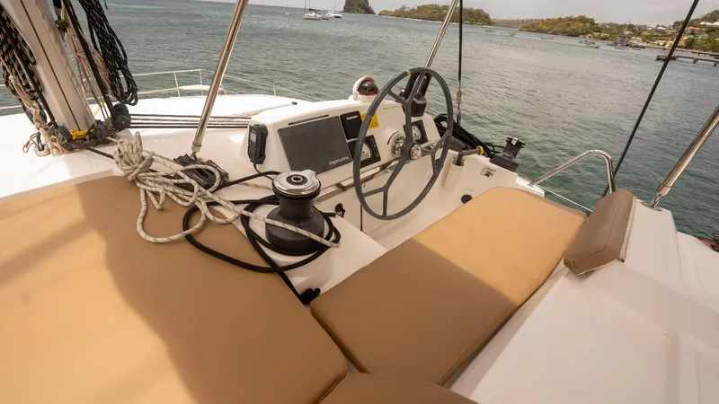 Viewfinder Yacht Photos Pics Steering area of a 2020 Bali 4.1 catamaran with beige seating and nautical equipment.