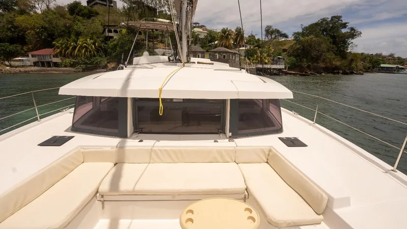 Viewfinder Yacht Photos Pics Bali 4.1 catamaran, 2020 model, with spacious deck and seating, docked near lush shoreline.