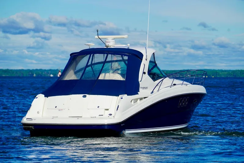  Yacht Photos Pics 2010 Sea Ray 390 Sundancer cruising on a calm lake under a clear sky.