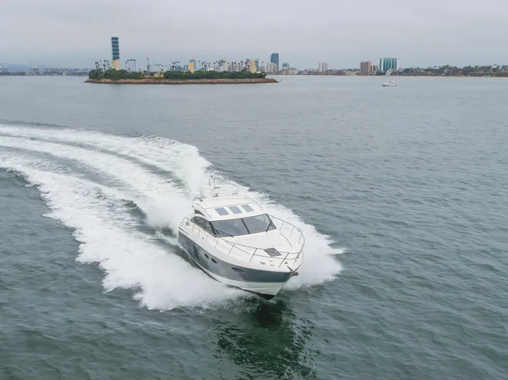 Release Me Yacht Photos Pics 2013 Princess V52 yacht cruising on open water near an island.