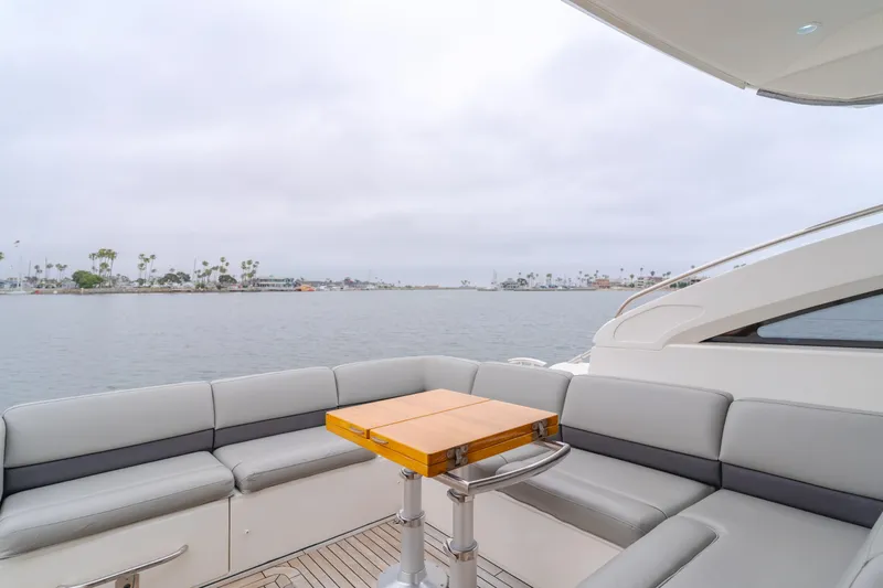 Release Me Yacht Photos Pics Luxurious 2013 Princess V52 yacht deck with seating and table, overlooking calm waters.