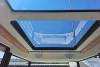 Glass sunroof of 2023 Nimbus Commuter 8 boat, showcasing clear blue sky.