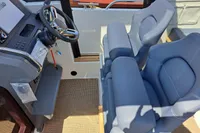 Interior of 2023 Nimbus Commuter 8 boat with steering wheel and cushioned seats.
