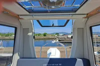 2023 Nimbus Commuter 8 interior with sunroof, dockside view, and waterway in the background.