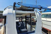 2023 Nimbus Commuter 8 boat with open sunroof, docked in a marina.