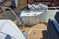 2023 Nimbus Commuter 8 boat deck with wooden flooring and stainless steel railing.
