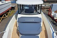 2023 Nimbus Commuter 8 boat with blue seating, docked at a marina.