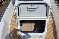 2023 Nimbus Commuter 8 boat storage compartment with open hatch, featuring teak flooring.