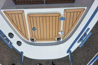 2023 Nimbus Commuter 8 boat deck with wood finish and stainless steel fittings.