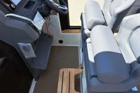 Interior of 2023 Nimbus Commuter 8 boat with steering wheel and cushioned seats.