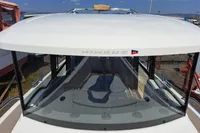 2023 Nimbus Commuter 8 boat with sleek design and spacious deck, docked under clear skies.