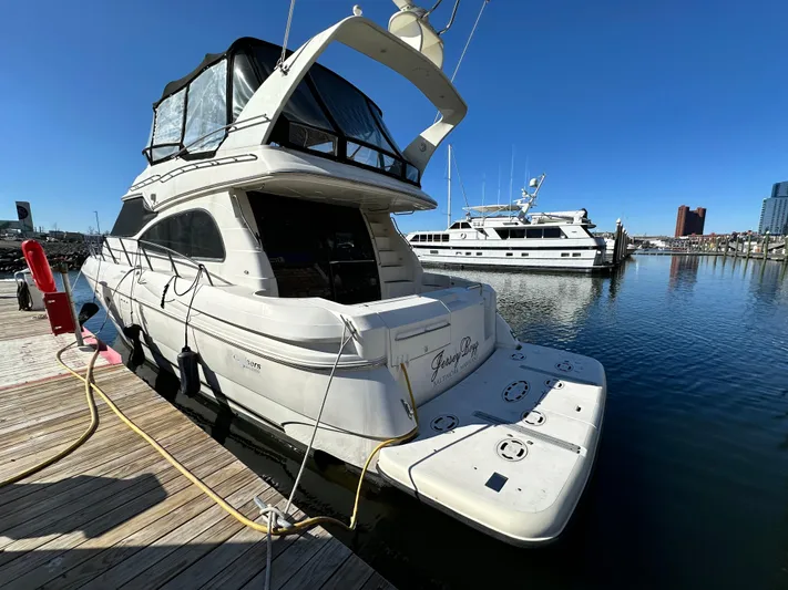  Yacht Photos Pics 1999 Cruisers 5000 Sedan Sport yacht docked at marina under clear blue sky.
