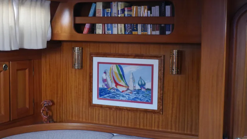 Maloose Yacht Photos Pics Interior of 2001 Malo 43 yacht with bookshelf and nautical artwork.