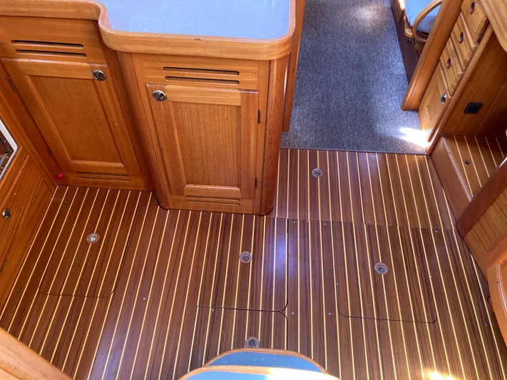 Maloose Yacht Photos Pics Wooden interior of a 2001 Malo 43 yacht, featuring striped flooring and cabinetry.