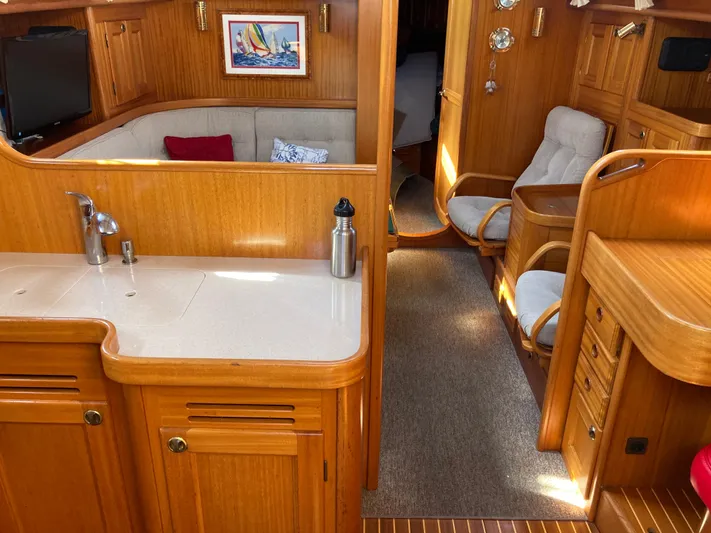 Maloose Yacht Photos Pics Interior of 2001 Malo 43 yacht with wooden finish, cozy seating, and kitchenette.