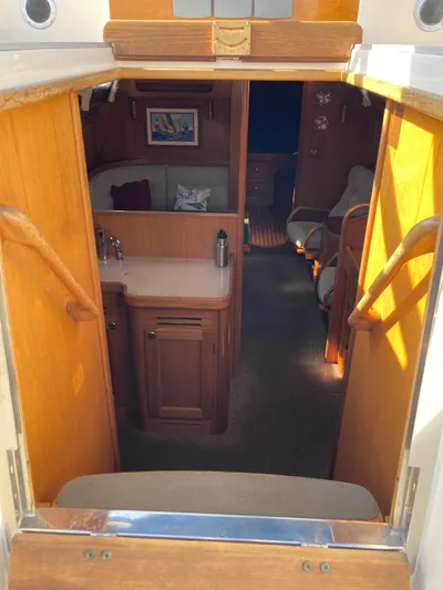 Maloose Yacht Photos Pics Interior view of a 2001 Malo 43 sailboat, featuring wooden cabinetry and seating area.