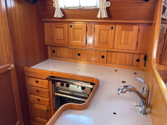 Maloose Yacht Photos Pics Wooden yacht kitchen interior with cabinets, stove, and sink; Malo 43, 2001 model.