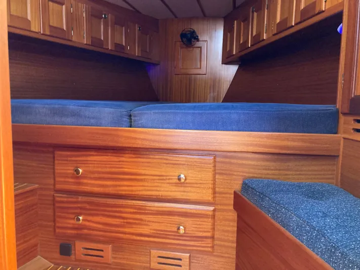 Maloose Yacht Photos Pics Interior cabin of 2001 Malo 43 yacht with wooden finish and blue cushions.